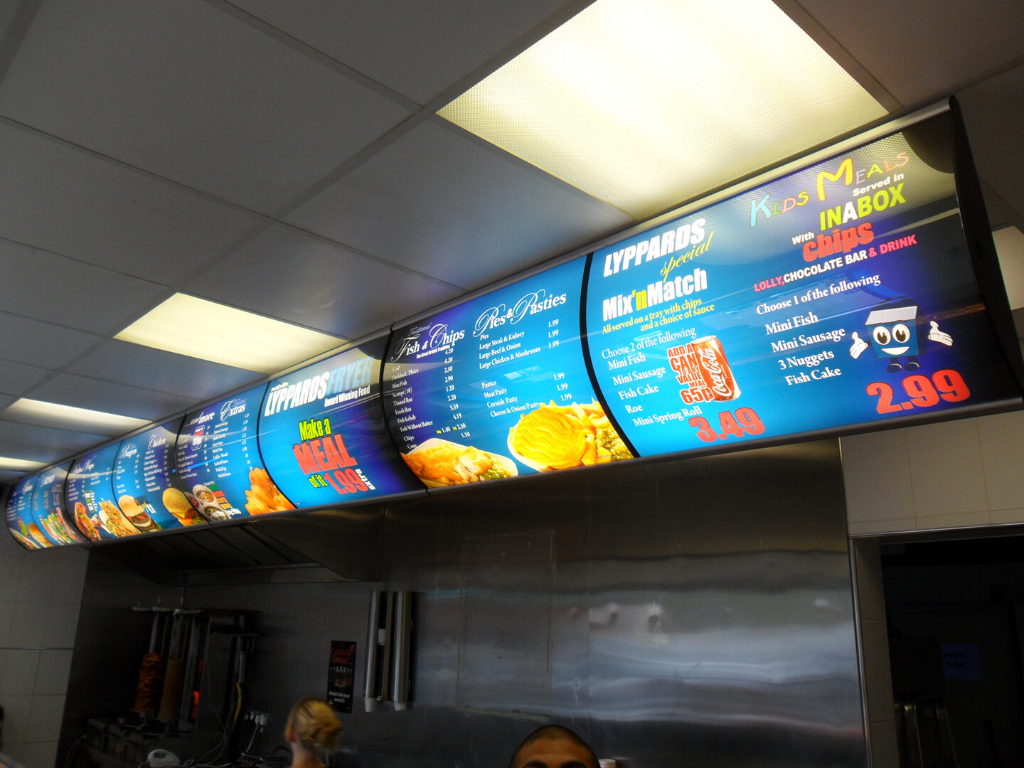 Curved blue illuminated menu run above the counter at Lyppards