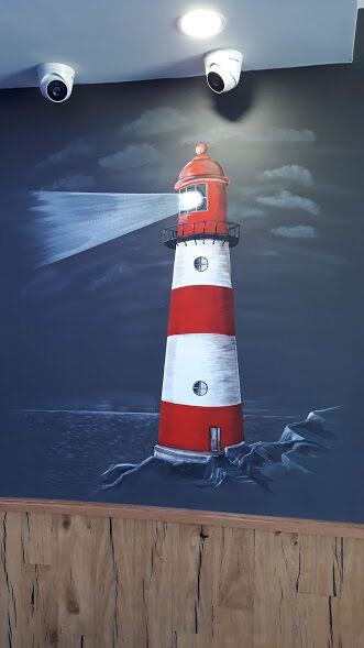 Hand-painted lighthouse mural on timber cladding