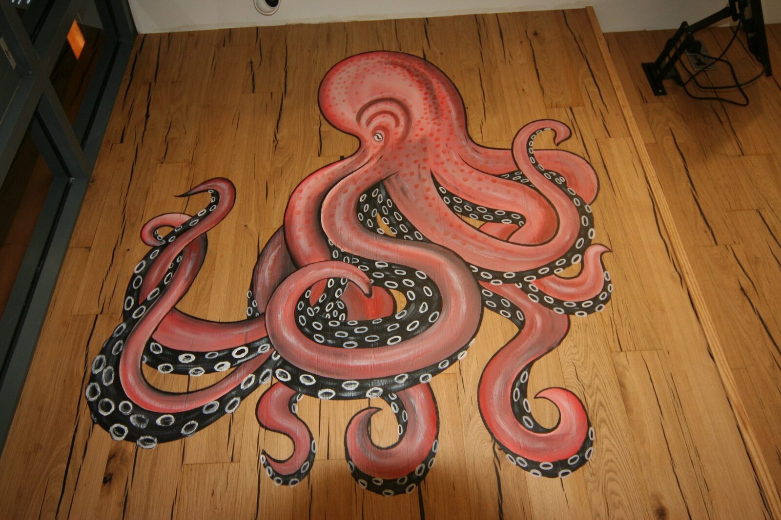 Hand-painted octopus artwork on a timber floor